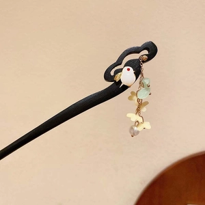 Detail of a Chinese hair stick featuring white bird charm and elegant beaded tassels