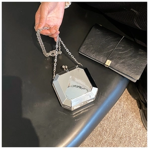 Detailed top view of a silver geometric acrylic box bag with a polished chain strap