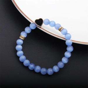 Vista macro del bracciale di perline occhio di gatto blu con dettagli dorati e cuore