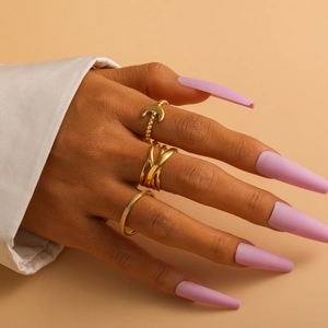 Close-up of three-piece gold titanium steel ring set with moon and cross patterns