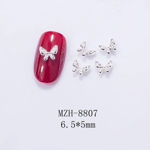 Macro view of 3D silver metal butterfly nail charms with rhinestones and dimensions