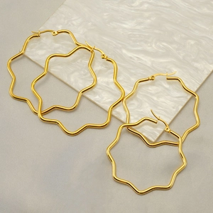 Minimalist 18K gold plated stainless steel wave earrings on white marble card