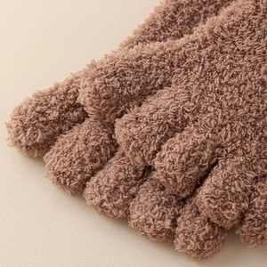 Macro shot of soft brown coral fleece winter socks showing plush texture and fuzzy material