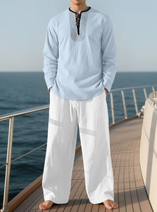 Men's light blue linen shirt and white trousers set worn on a boat deck for beach vacation