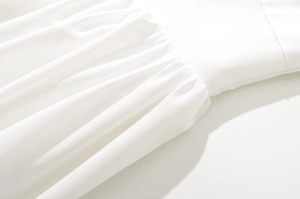 Detailed macro view of pure white fabric texture and lace trim on a long dress