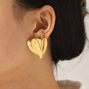 Elegant 18K gold-plated stainless steel flower-shaped stud earrings worn by a model