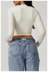 Slim fit white yoga long sleeve top and blue jeans showing the back silhouette and curves