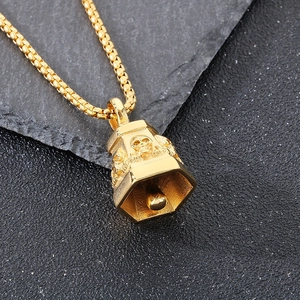 Macro view of gold punk skull bell pendant with detailed engraving on grey stone background