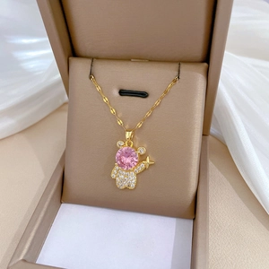 Close-up of gold bear necklace with pink crystal head and sparkling white zircon pavé
