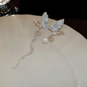 Boucles d'oreilles papillon asymétriques en argent avec cristaux bleus et glands
