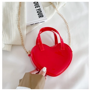 Detailed view of red heart-shaped jelly bag with glossy finish and gold metal chain