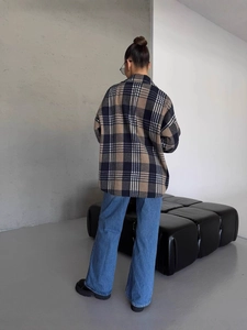 Women's oversize black and brown plaid shirt jacket and blue jeans casual look