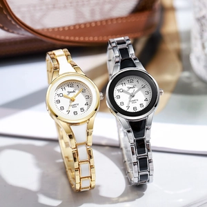 Close-up of gold and silver quartz wristwatches with round dials and metal chain bracelets