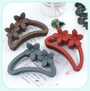 Detailed view of matte flower hair claws in brown, dark red, and greyish blue colors