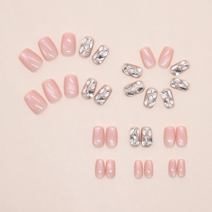 Detail of pink cat eye press-on nails with glitter, rhinestones and butterfly accents