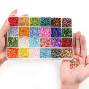 Close-up of 24-grid organizer box filled with colorful glass seed beads for DIY jewelry