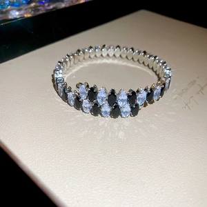 Detailansicht eines flexiblen Silberarmbands mit schwarzen und weißen Zirkonia-Steinen
