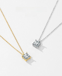 Macro view of square princess-cut zircon pendants in gold and silver four-prong settings