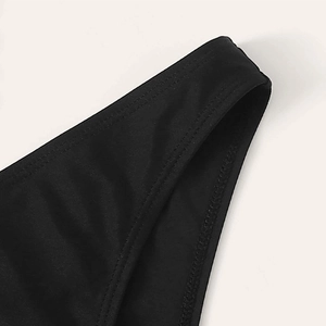 Detailed close-up of double-stitched seams on premium black knitted swimwear fabric