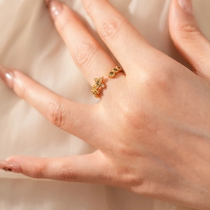 Détail d'une bague dorée vintage avec étoiles et zircons sur la main d'un mannequin