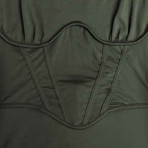 Gros plan sur les coutures de la taille et la texture du tissu de la robe verte