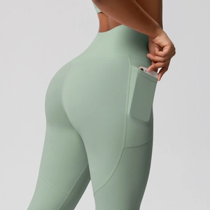 Close-up of mint green high-waisted yoga pants with side pockets and seam details