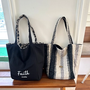 Furry leopard print and black nylon tote bags displayed on a wooden bench