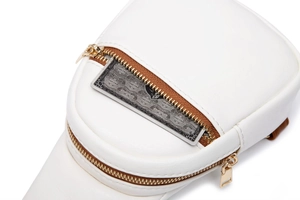 Detail of white faux leather chest bag showing front pocket capacity and gold zipper hardware