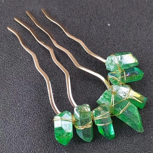 Macro detail of handmade gold wire-wrapped green crystal hair comb for weddings