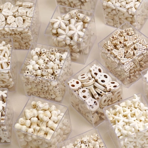 Detail view of cream synthetic turquoise beads in various shapes for DIY jewelry making