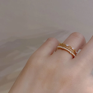 Detail of multi-layer gold ring with white pearls and sparkling cubic zirconia stones