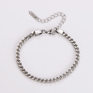 Detailed macro view of silver stainless steel Cuban link bracelet with lobster clasp