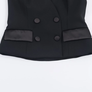 Close-up of black double-breasted vest featuring elegant satin flap pockets and tailoring