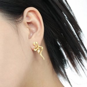Snake textured gold stud earrings with cubic zirconia inlay on model ear