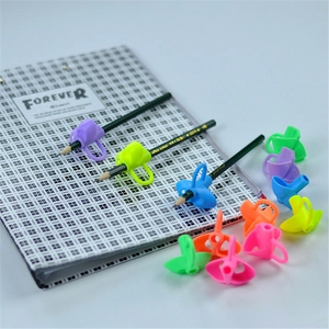 Close-up of colorful silicone pencil grips on a notebook for writing posture correction