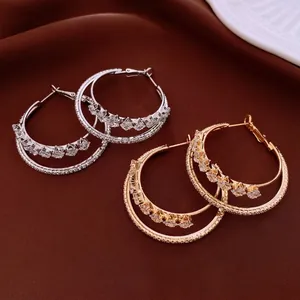 Gold and silver layered hoop earrings with zircon pavé setting on silk background