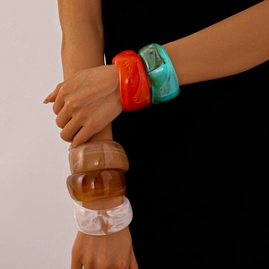 Chic marbled acrylic chunky bangles set in various colors on a model's wrist