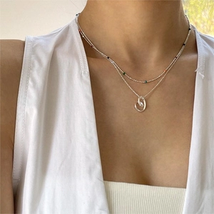 Close-up of minimalist S925 silver layered necklace with colorful beads and interlocking rings