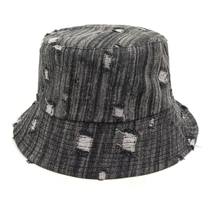 Close-up of distressed dark grey denim bucket hat showing vintage ripped hole details