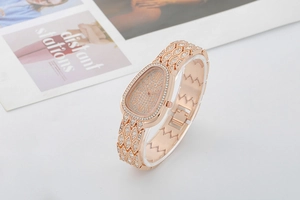 Detailed view of rose gold snake-shaped watch with crystal-encrusted bracelet dial