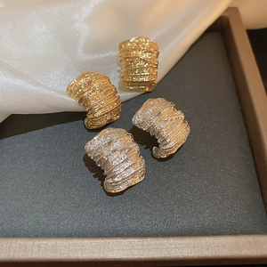 Minimalist C-shaped crumpled metal earrings in gold and silver finish with wrinkled texture