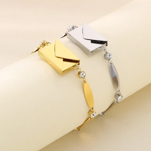 Détail des bracelets enveloppe en or et argent avec des pierres de zircon scintillantes