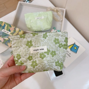 Close-up of a floral mini canvas pouch with a zipper and a Simple Wish fabric label
