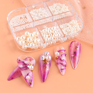 6-grid box with various white pearls, gold beads and pink marble nail art samples
