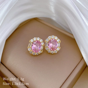 Macro detail of pink oval gemstone earrings with zircon halo on gold plated setting