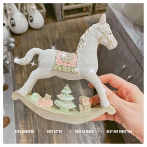 Detailed view of resin rocking horse with woven texture and mini Christmas tree decor