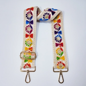 Detail of bohemian guitar strap with colorful floral embroidery and gold metal hooks