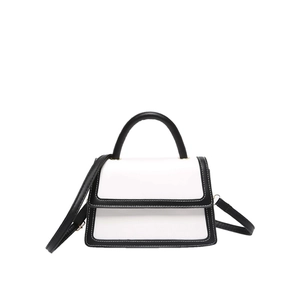 Elegant black and white contrast leather crossbody bag with gold hardware and top handle