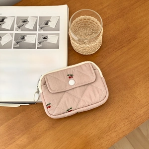 Pink quilted cherry card holder on wooden desk with books for natural aesthetic