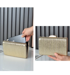 Detailed capacity view showing a smartphone inside a pleated gold evening clutch bag